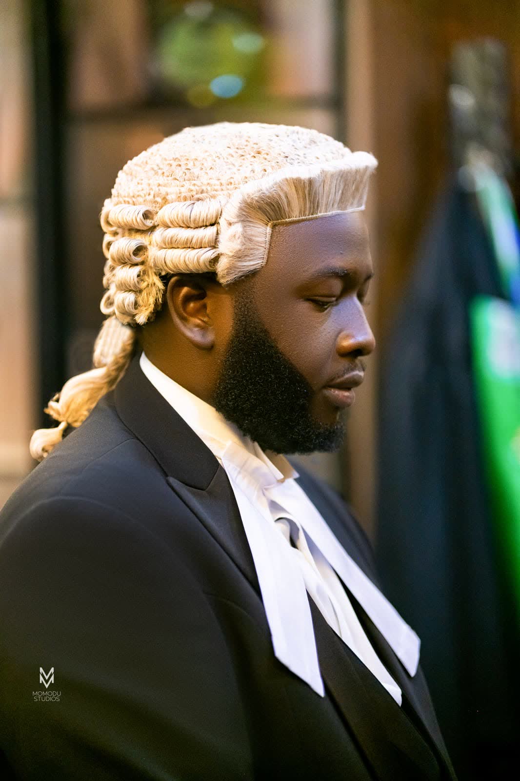 A bearded new lawyer in a barrister's wig, photographed in profile
